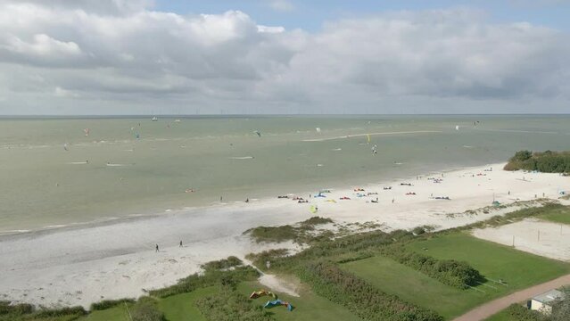 Aerial view of people doing kite surfing along the beach sunny day, Netherlands