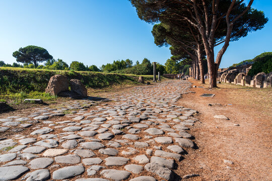 View of paved roman road in ancient Ostia archaeological park in Italy