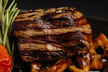 Juicy beef tenderloin steak with flavorful mushroom sauce, served elegantly on a sleek black plate