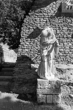 Black and white photo of roman statue in the archaeological site of Ancient Ostia in Italy