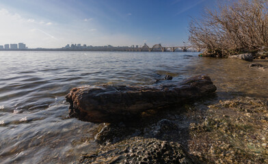 Dnipro river, Dnipro city, Ukraine. Cityscape with blue sky with clouds and river, and city bridge.