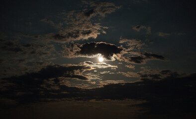 Full moon shining at night with clouds.