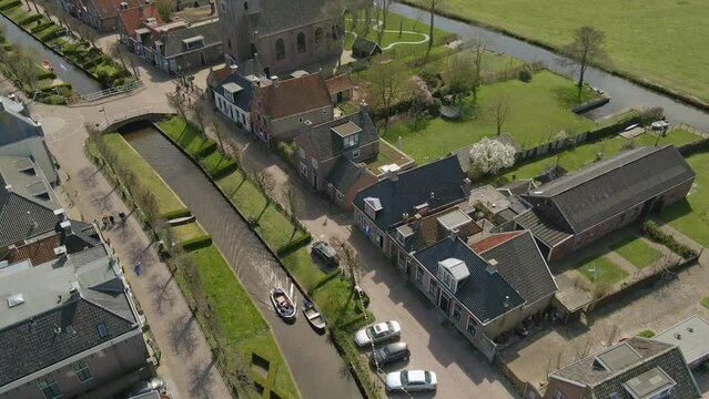 Aerial view of small boat cruising in canal (Ee gracht) during summer, Ijlst, Netherlands