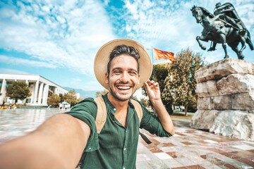 Happy tourist taking selfie at Skanderbeg square in Tirana, Albania - Smiling handsome young man...