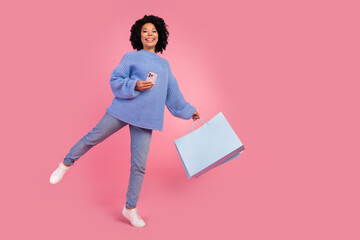Full size photo of pretty young girl keep balance shopping bags device wear trendy blue knitwear...