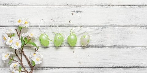 Easter eggs in a row and decorative cherry branch on a white wooden background. Top view, flat lay, banner. - 758906671