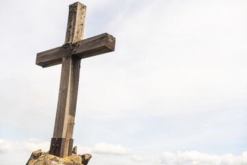 cross made of stone with blue sky background.