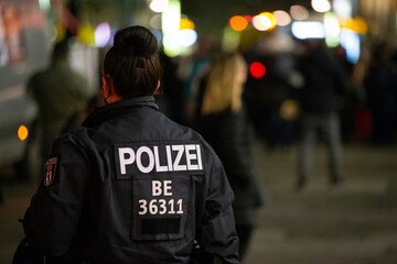 Polizistin einer Einsatzhundertschaft bei Corona-Protest in Berlin Mitte Nachts - obrazy, fototapety, plakaty