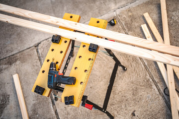 Electric drill and wooden plank on a table outdoors