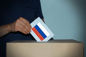 voters to vote on a single voting day in Russia at a polling station. male hand of a voter lowers...