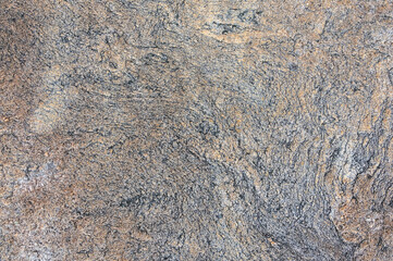 Detailed close up view of a textured granite surface, showcasing the intricate patterns and colors found in the natural stone.