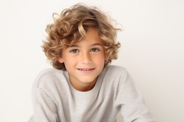 Portrait of a cute little boy with blond curly hair on a white background