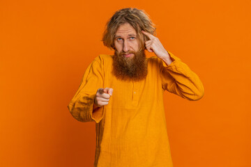 You are crazy, out of mind. Confused Caucasian man pointing at camera and showing stupid gesture,...