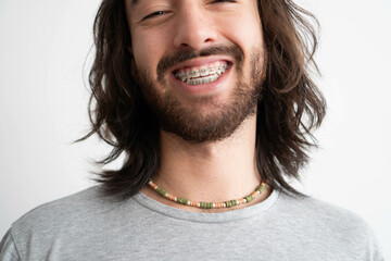 close up of a young latin man with braces wearing a colorful ceramic necklace