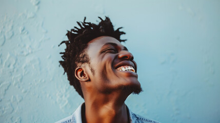 A man's joyful expression is captured against a cool blue backdrop, highlighting his contagious smile and carefree attitude. The image is a celebration of happiness and positive energy