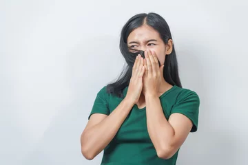 Foto op Canvas Young Asian frustrated woman with green t-shirt pinches her nose with disgust on her face, reacting to a bad smell in isolation over background. © NanSan