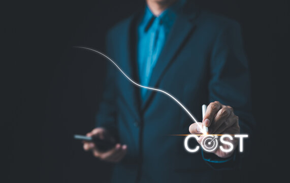 Cost reduction concept. Cost Management, Businessman work on company cost saving. The word 'COST' appears as decrease with down arrow. Economy recession, low budget, Effective business, Expense reduce