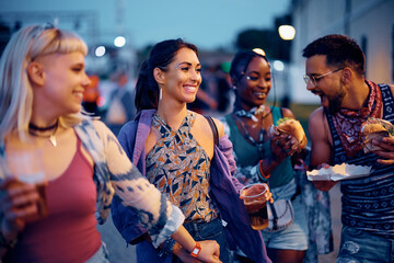 Happy woman having fun with friends during open air music festival in summer.