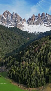 Spring landscape with shurch in Santa Magdalena village, Italian Dolomites Alps, in South Tyrol, Val di Funes, Italy. Vertical video