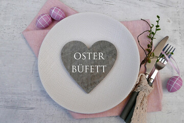 Osterbüfett: Besteck mit Teller und Oster Dekoration auf einem Tisch .

