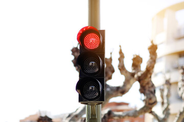 LED red light traffic light on defocused european buildings and trees background. City crossing...