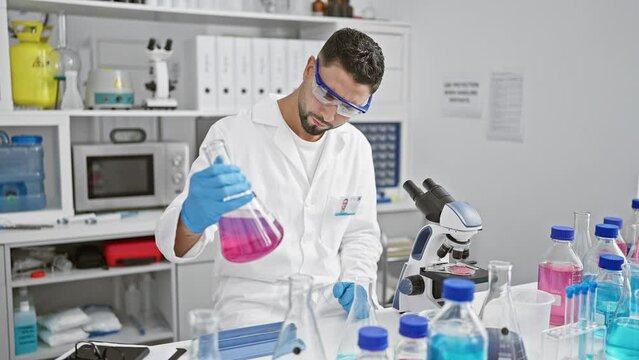 A focused man in lab coat analyzing chemicals in a modern laboratory.
