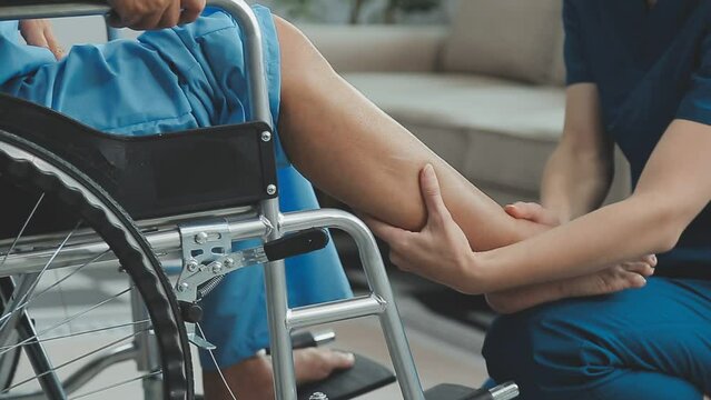 Asian female physiotherapist helping senior older woman stretching hamstring, Rehabilitation physiotherapy, elderly. Causes knee pain, swelling, redness, stiffness in knee, clunking noise in knee.