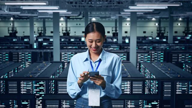 An Asian Business Woman Using Mobile Phone In Data Center
