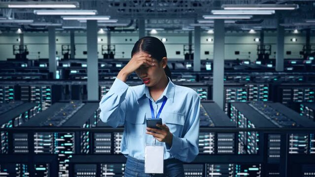An Asian Business Woman Not Satisfied And Shakes Her Head While Using Mobile Phone In Data Center