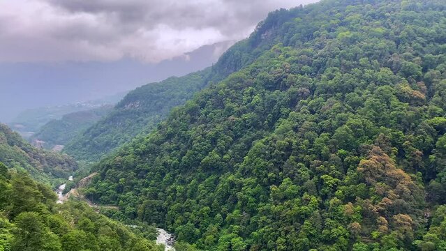 Storm clouds over mountains of Jang town deep in the  jang valley in tawang district of arunachal pradesh and surrounded by high mountains on a bright morning rainy day in arunachal pradesh in India.