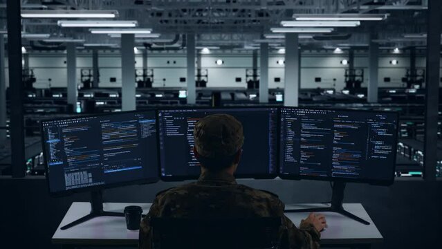 Back View Of Asian Military Having Headache While Write Code With Multiple Computer Screens In Data Center