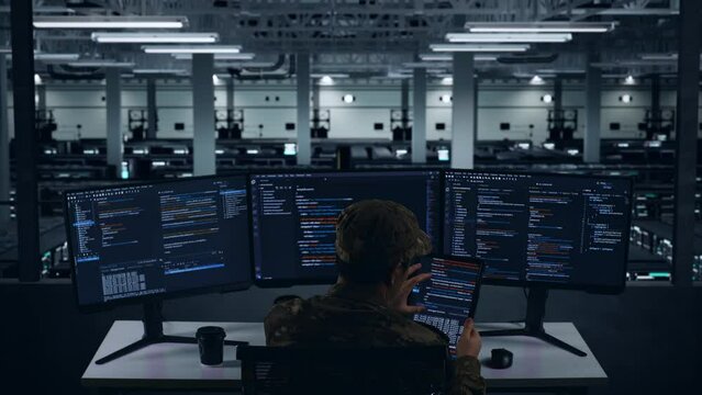 Back View Of Asian Military Working With Tablet While Write Code With Multiple Computer Screens In Data Center