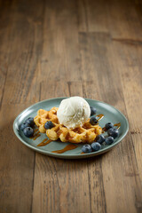 plate of belgian waffle with caramel sauce and blueberries - 758995279