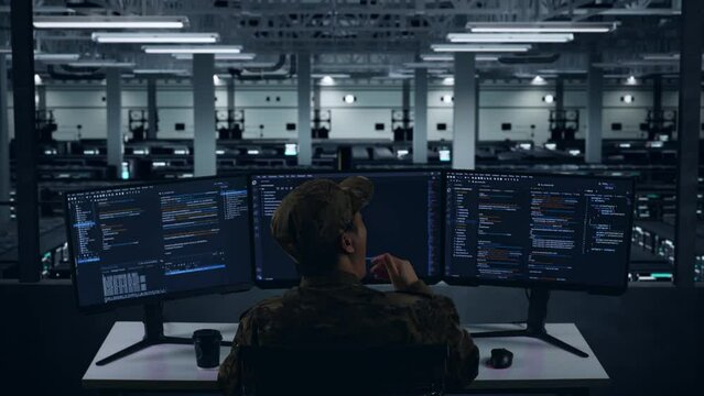 Back View Of Tired Asian Military Yawning Before Sleeping While Write Code With Multiple Computer Screens In Data Center