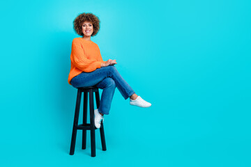 Full size photo of gorgeous cheerful girl sit chair empty space ad blank isolated on teal color...