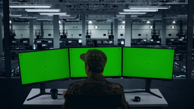 Back View Of Asian Military Drinking Coffee And Working With Mock Up Multiple Computer Monitor In Data Center