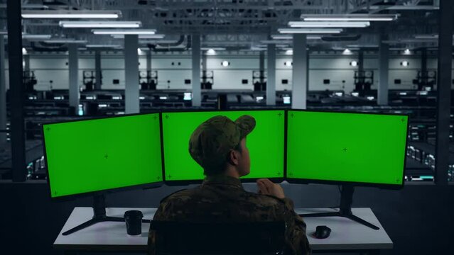 Back View Of Asian Military Thinking About Something Then Raising his Index Finger While Working With Mock Up Multiple Computer Monitor In Data Center