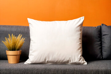 White cotton pillow on the sofa close-up. Orange walls in the background. Mock up