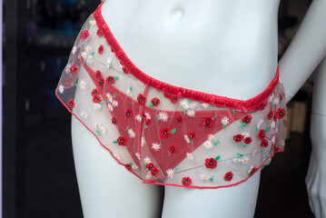 Closeup of red printed flowers on cheeky on mannequin in a fashion store showroom - 759006475