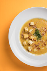 Creamy lentil soup with croutons and parsley