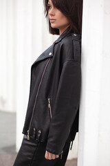 A beautiful girl with a stylish bob haircut is walking around the city against the background of...
