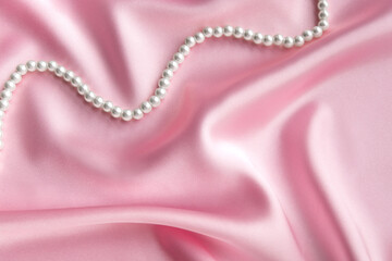 Pearls on silk background with space for message