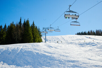 Wyciąg narciarski, kanapa, kolej linowa w ośrodku narciarskim w górach. śnieg, zima, słońce. Pod światło. - obrazy, fototapety, plakaty