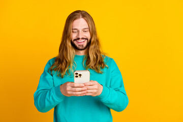 Portrait of cheerful person use apple iphone gadget chatting empty space isolated on yellow color...