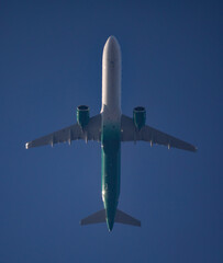 Commercial Airliner Passing Directly Overhead in Deep Blue Sky