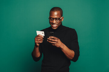 Young man using a credit card for online shopping with his smartphone