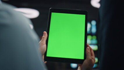 Businesspeople hands holding greenscreen tablet computer at datacenter closeup. 
