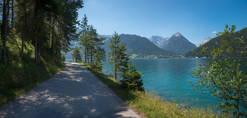 bike and walkway along lake Achensee, view to Pertisau tourist resort and karwendel alps