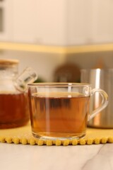 Aromatic tea in glass cup on light marble table