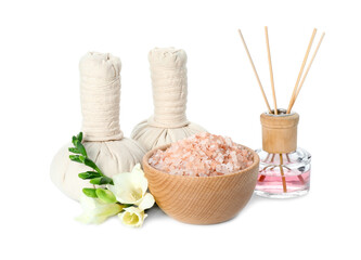 Spa composition. Herbal massage bags, sea salt, reed air freshener and beautiful flowers on white background